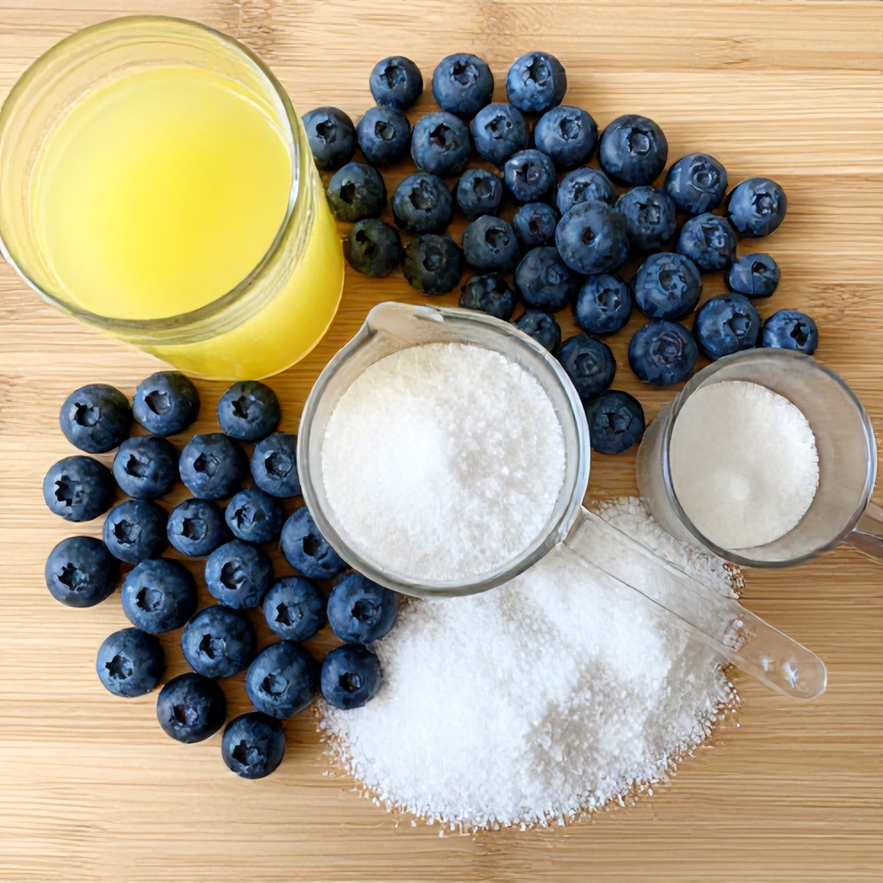 Blueberries, lemon juice, and sweetener on a wooden surface
