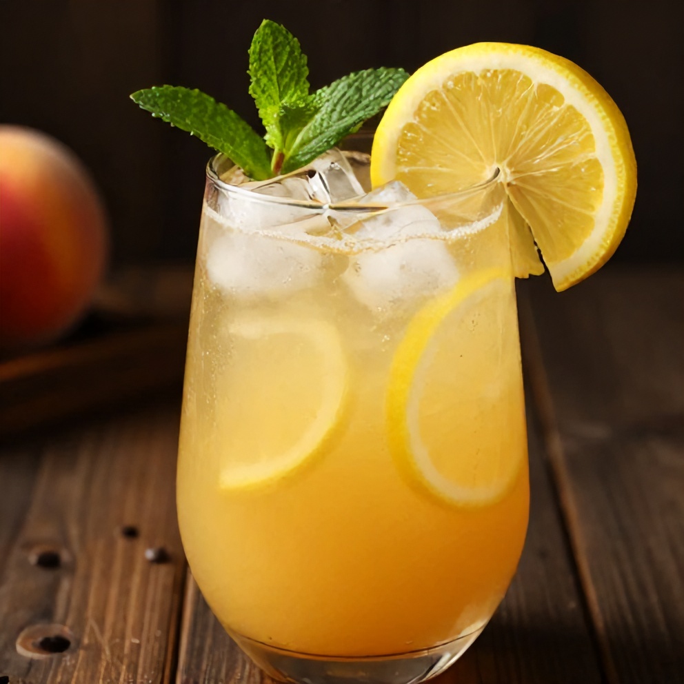 Glass of Peach Ginger Lemonade garnished with a lemon slice and fresh mint