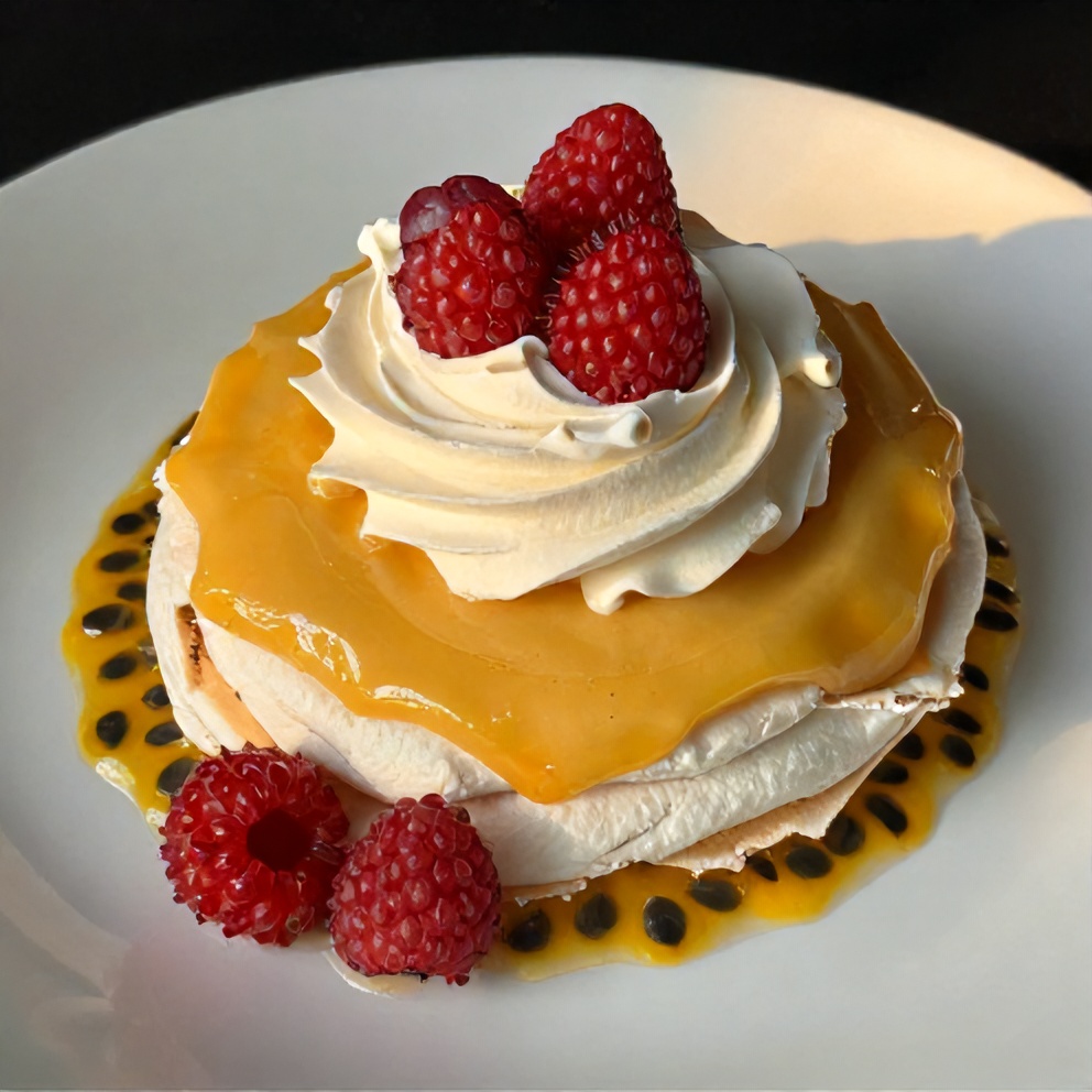 Individual Passionfruit Pavlova with passionfruit curd, whipped cream, and fresh berries