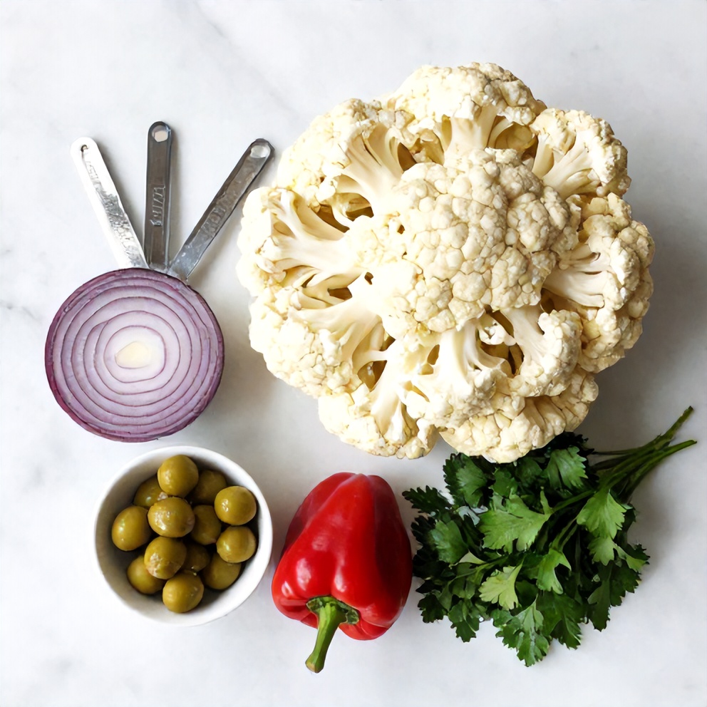 Raw Ingredients for Marinated Cauliflower Salad: Cauliflower, Red Onion, Bell Peppers, Olives, and Capers